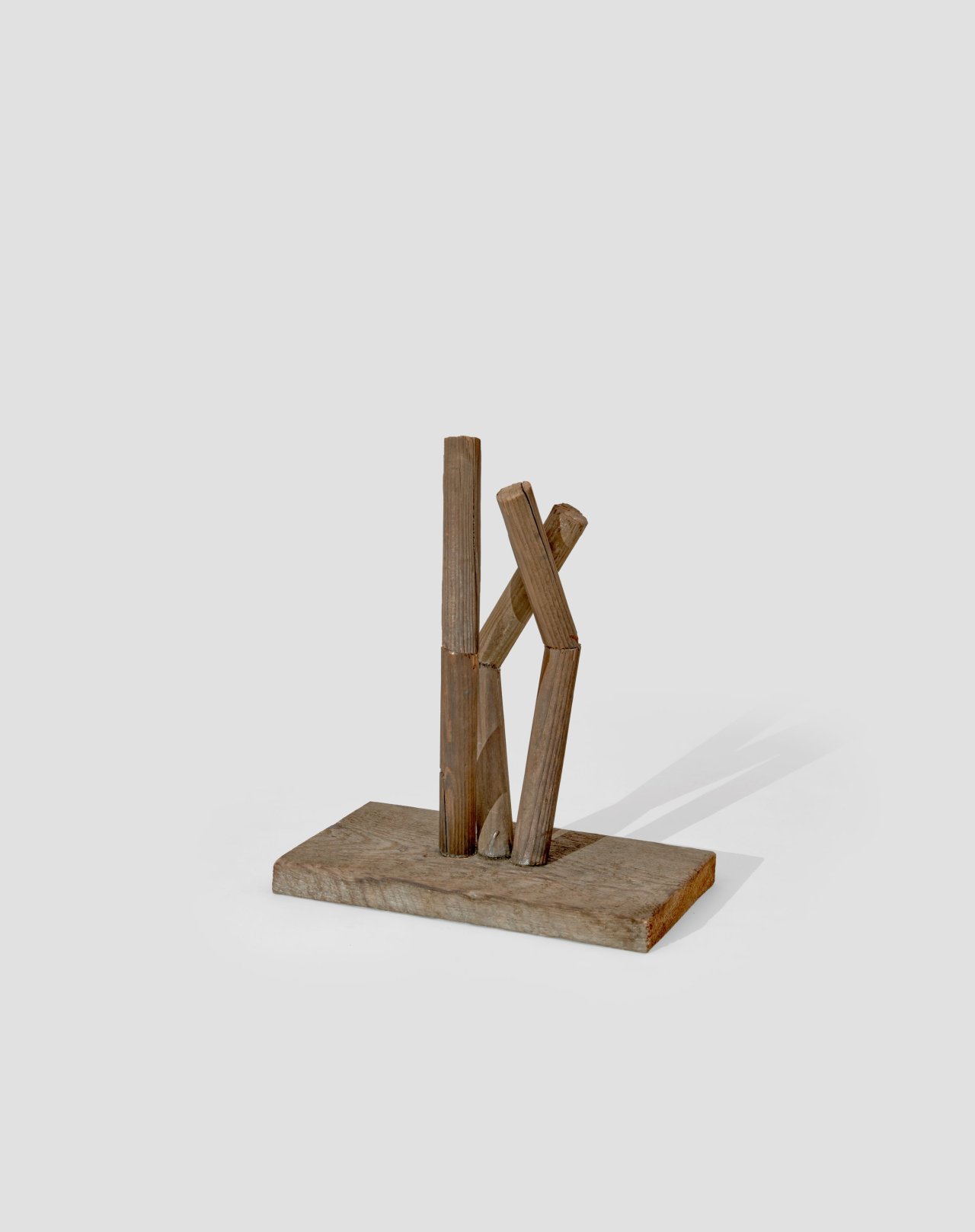 This picture shows the following artwork: Hermann Glöckner. Aufrichtung von drei geteilten und gewinkelten Rundhölzern auf Holzplinthe. 1978.